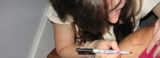 A girl drawing a tattoo in texta