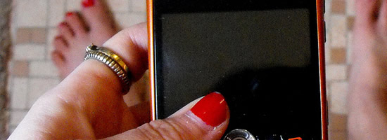 A young woman looks at her phone.